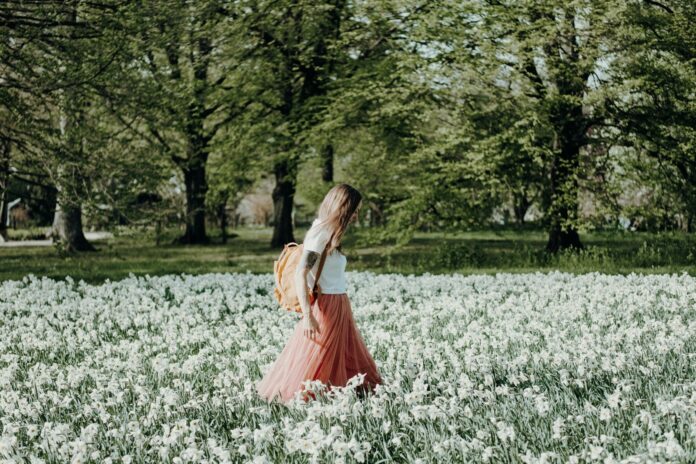 Photo by Nadine Rupprecht woman walking on flower field