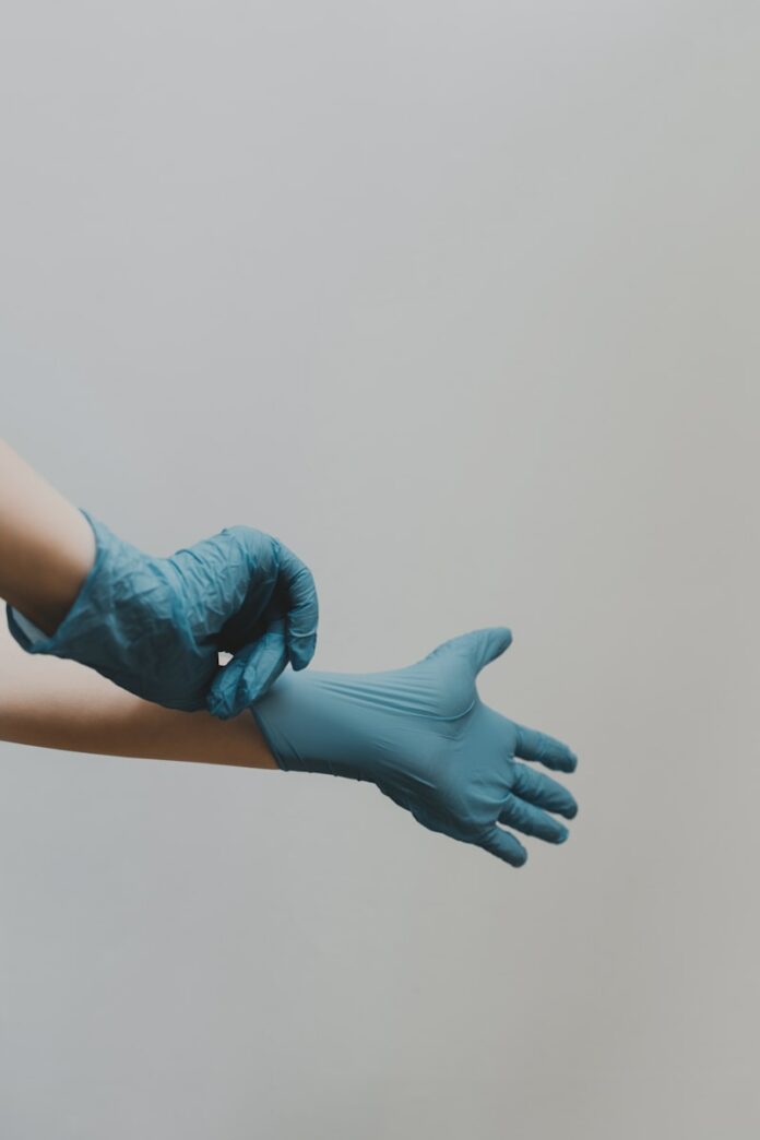 Photo by Clay Banks person in blue gloves and blue denim jeans