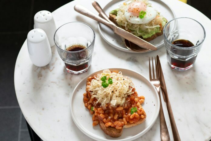 Photo by Monika Borys a white plate topped with food next to glasses of liquid