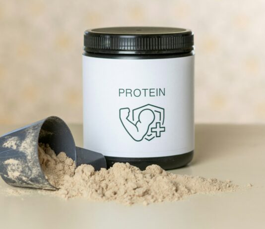 피트니스 성과를 높이는 영양 보충제: 효과와 사용법 a jar of protein powder next to a scoop of powder