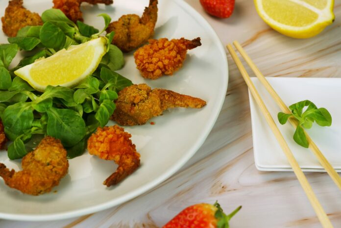 Photo by Babs Gorniak a white plate topped with shrimp and greens