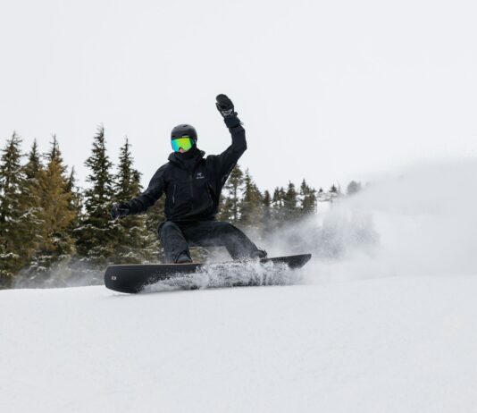 겨울철 운동으로 다이어트 성공하기 a man riding a snowboard down a snow covered slope