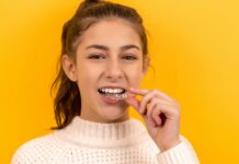 치아 교정의 이점과 고려 사항 smiling woman in white knit sweater