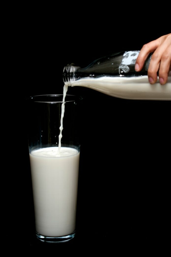 Photo by engin akyurt person pouring milk on clear drinking glass