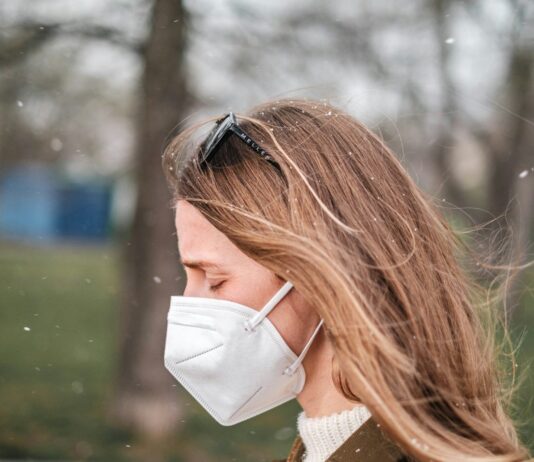 미세먼지와 건강: 호흡기 보호를 위한 생활 습관 a woman wearing a face mask in a park