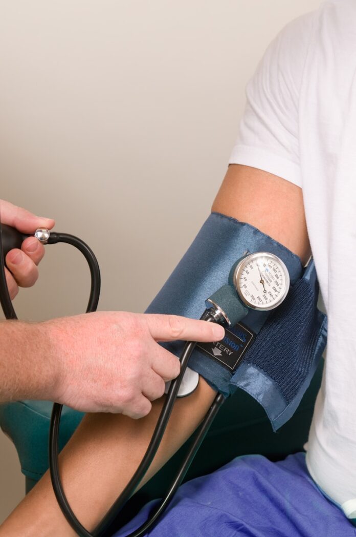 Photo by CDC a doctor checking the blood pressure of a patient