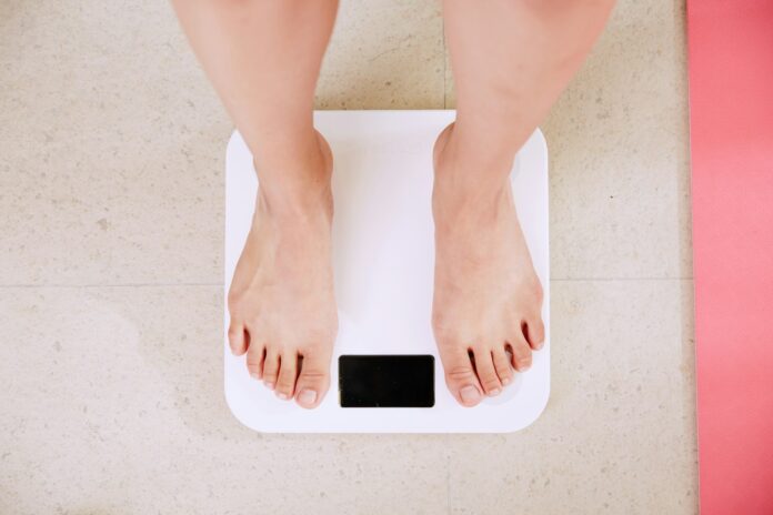 Photo by i yunmai person standing on white digital bathroom scale