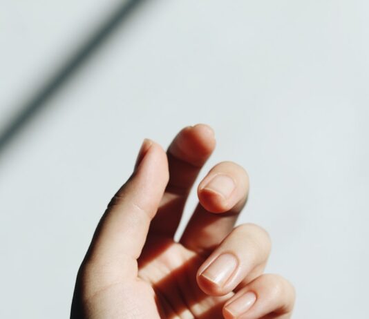 “손톱이 잘 갈라지고 울퉁불퉁해요”… 몸속 신호를 말해주는 ‘네일 건강’ persons left hand on white table