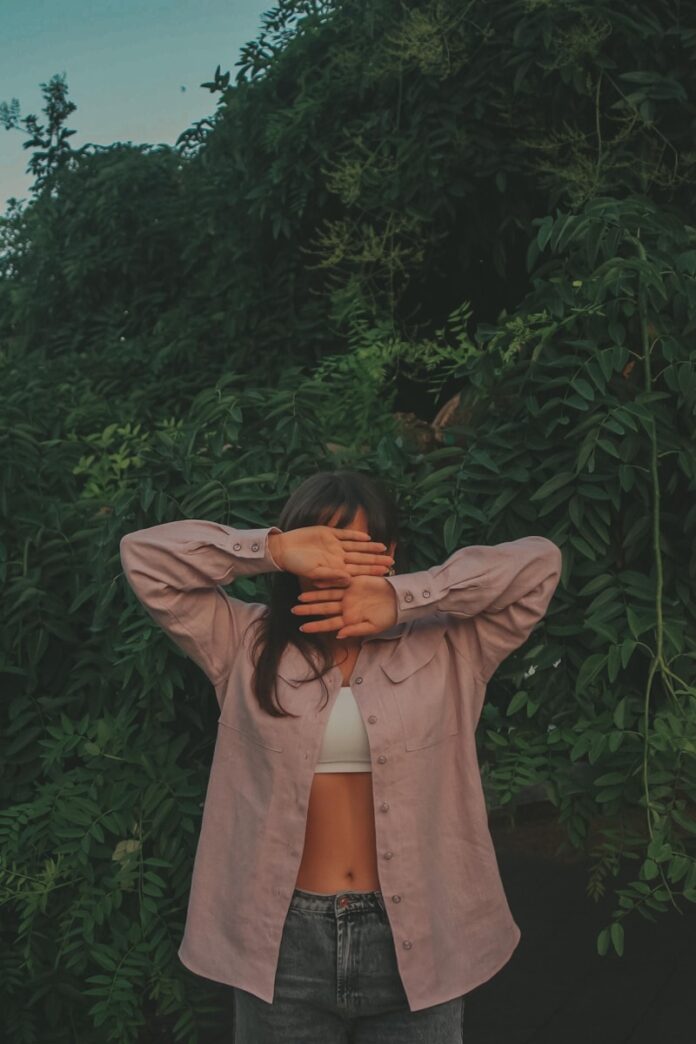 Photo by Kristina Musiienko woman in gray long sleeve shirt covering her face with her hands