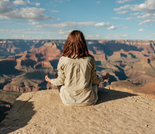 명상을 통해 마음을 안정시키고 건강을 챙기는 법 woman sitting on hill