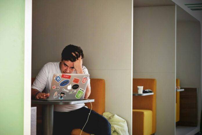 Photo by Tim Gouw man wearing white top using MacBook