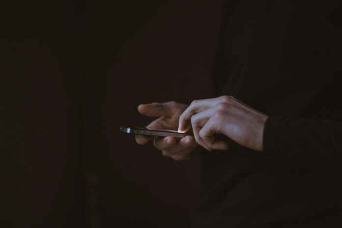 Photo by Gilles Lambert silhouette photo of person holding smartphone