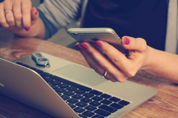 Photo by Firmbee.com woman holding silver iPhone 6