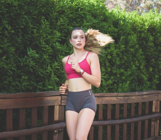 “필라테스, 바쁜 일상 속 균형 찾기의 비밀” Young woman running on a wooden path outdoors path outdoors.