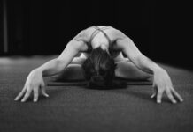 인요가(Yin): 근육보다 깊은 곳, 결합 조직을 늘리는 ‘기다림의 미학’ woman in white tank top bending her body on floor