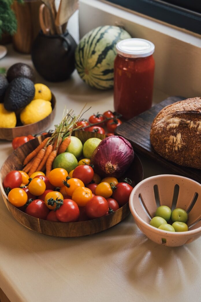 Photo by Ahmet Koç Fresh produce including tomatoes, carrots, and avocados on a counter.