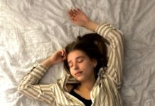 수면은 최고의 영양제: 잠든 사이 일어나는 근육 회복과 지방 분해의 골든타임 woman in white and black striped long sleeve shirt lying on bed
