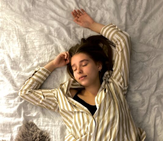 수면은 최고의 영양제: 잠든 사이 일어나는 근육 회복과 지방 분해의 골든타임 woman in white and black striped long sleeve shirt lying on bed
