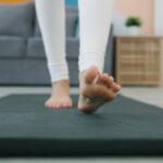 “마음챙김 운동, 일상 속 스트레스 해법으로 주목받다” Bare feet walking on a yoga mat