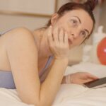 만성피로, ‘작은 생활 혁신’이 시작이다 Woman lying on bed with phone and balloons