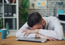 “만성피로, 일상 속 소소한 변화로 극복하기” a man sitting at a desk with his head in his hands