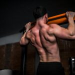 근육, 더 이상 운동선수만의 전유물 아니다…일상 속 근육 관리법 주목 topless man in black shorts holding orange bar