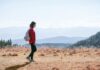 늘어나는 ‘걷기 챌린지’, 일상 속 건강 습관 만들기 열풍 a man with a backpack walking across a dry grass covered field