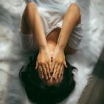 바쁜 일상 속에서도 실천하는 ‘마음 챙김’… 현대인의 스트레스 관리법 a woman holds her hands over her face